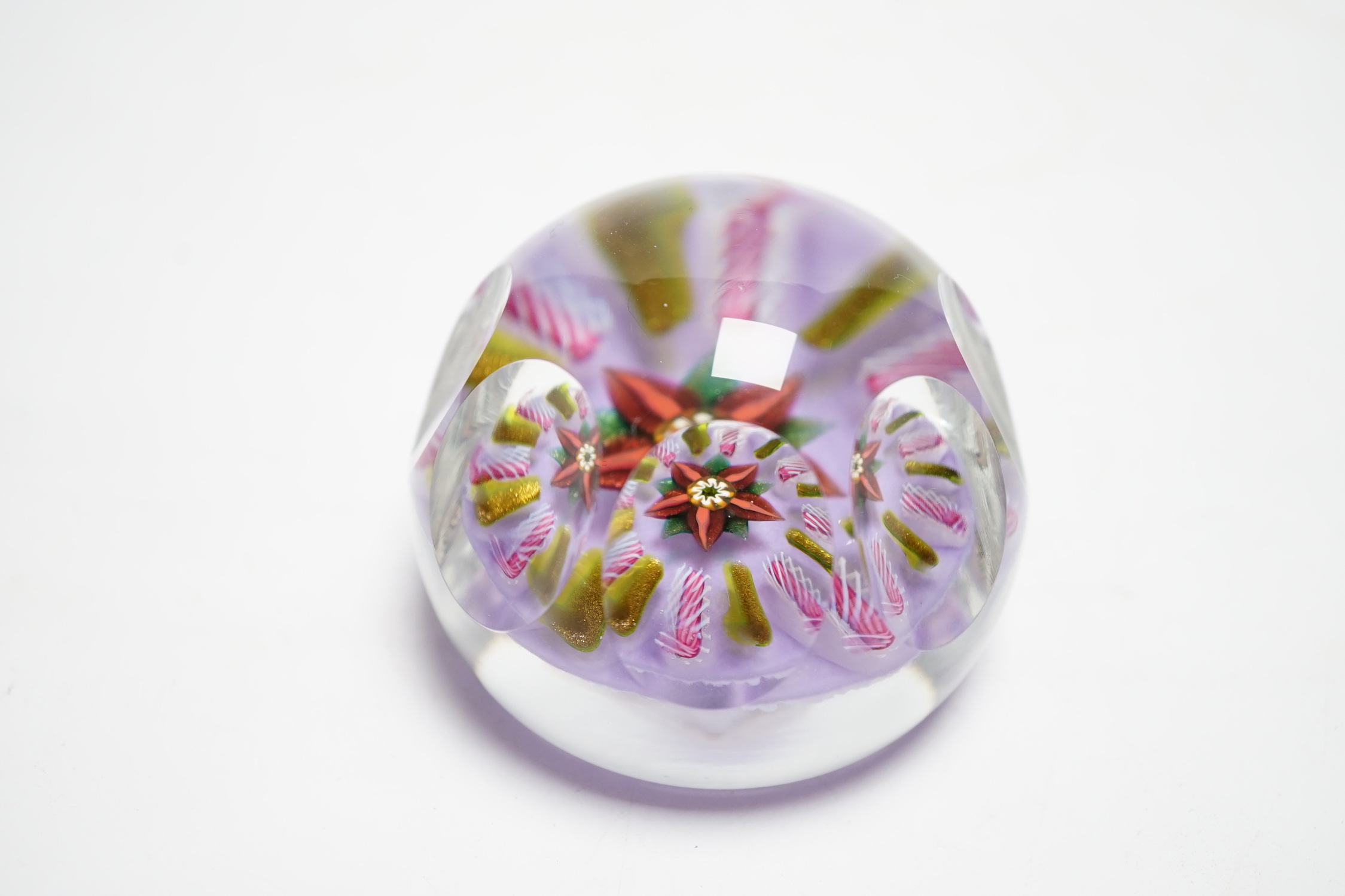 A Paul Ysart faceted ‘flower’ glass paperweight, Harland period, the central flower within aventurine and latticino spokes on a violet ground, PY paper label to base, 6.5cm